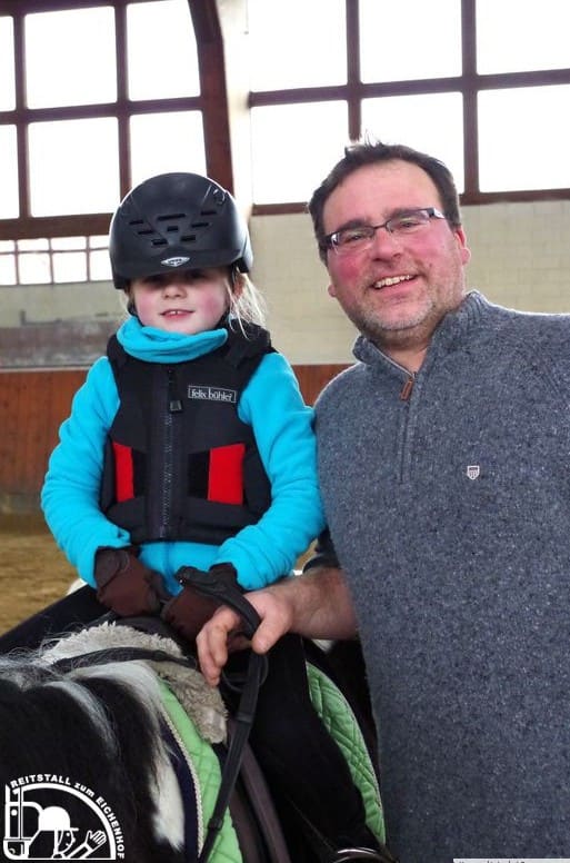 Ein kleiner Junge sitzt stolz auf dem Pony